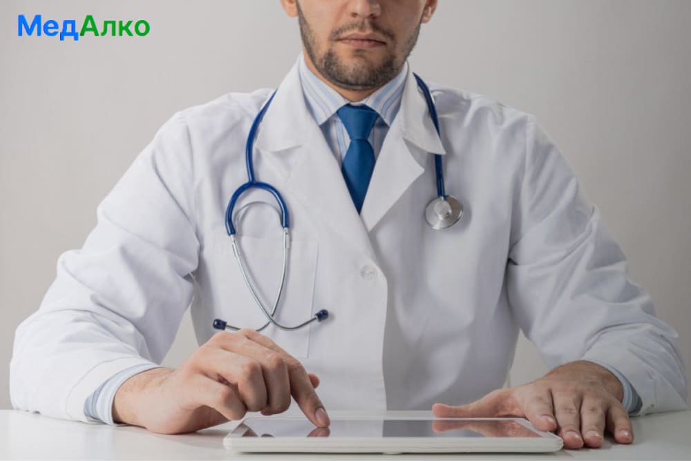 Врач нажимает на планшет в клинике "МедАлко"
